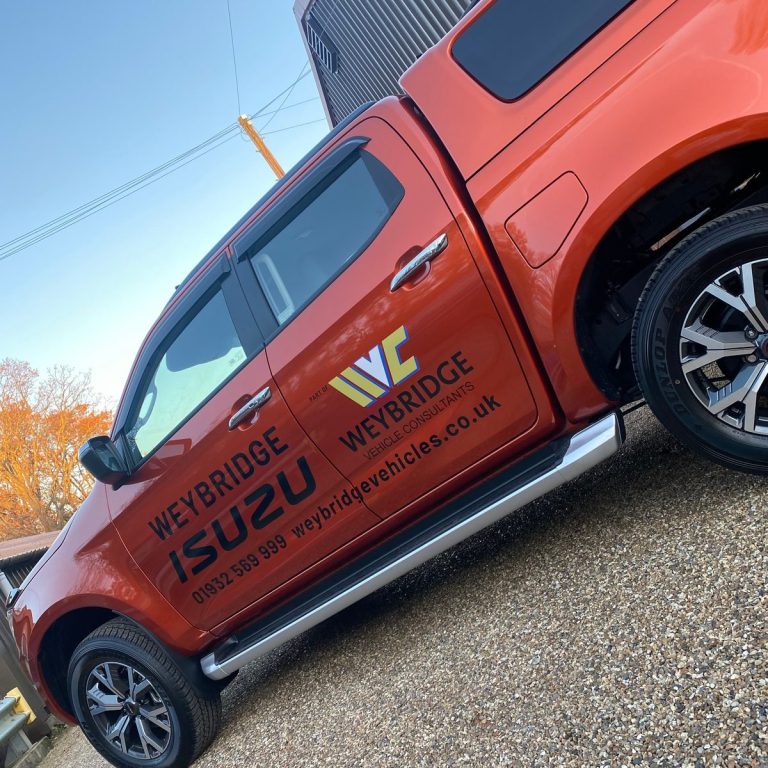 Orange Isuzu pickup with Weybridge Vehicle Consultants lettering and web address on doors