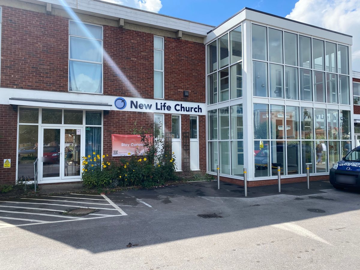 Brick and glass building with 'New Life Church' fascia sign above the entrance