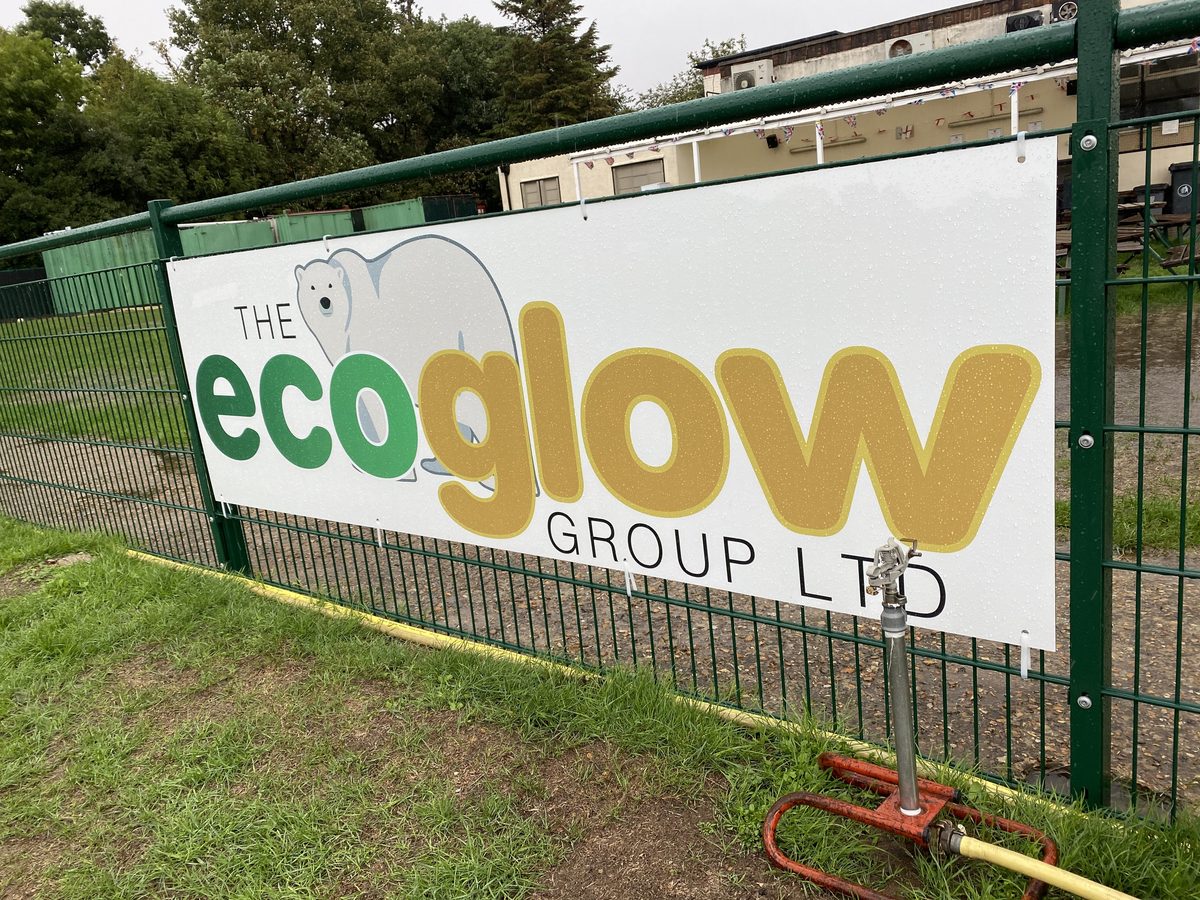 The Ecoglow Group Ltd sign with polar bear logo fixed to green mesh fencing