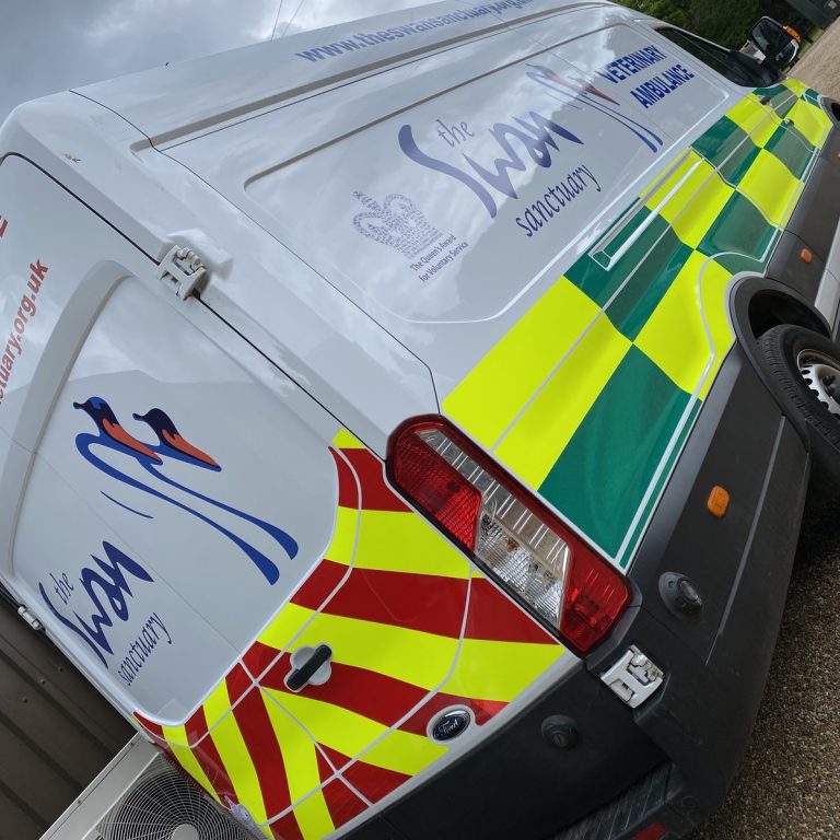 Close-up of Swan Sanctuary veterinary ambulance van rear with red and yellow chevrons and swan logo
