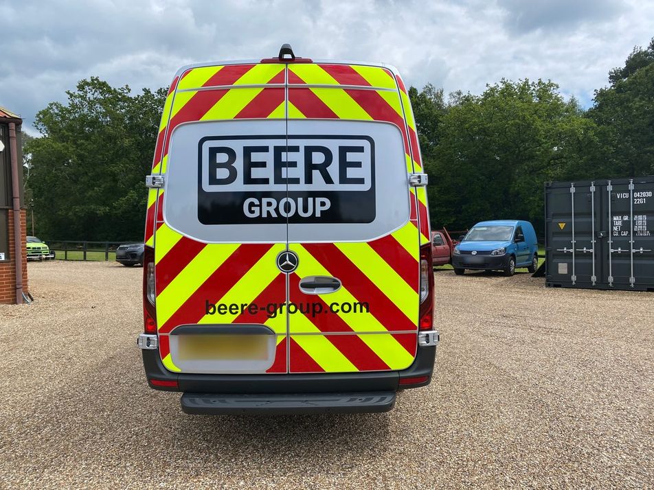 Rear of a Mercedes van with full red and yellow Chapter 8 chevrons, Beere Group logo and web address