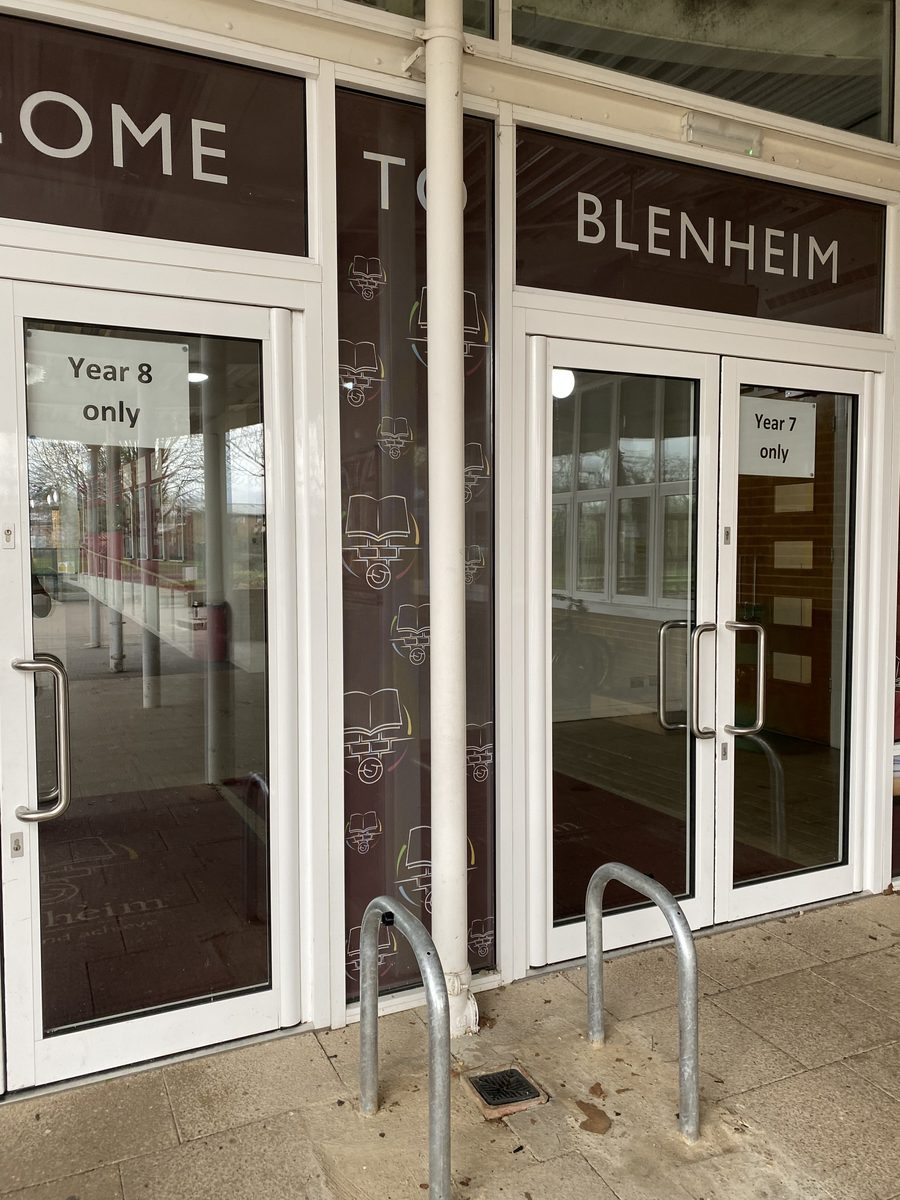 Blenheim school entrance doors with burgundy 'Welcome to Blenheim' window graphics