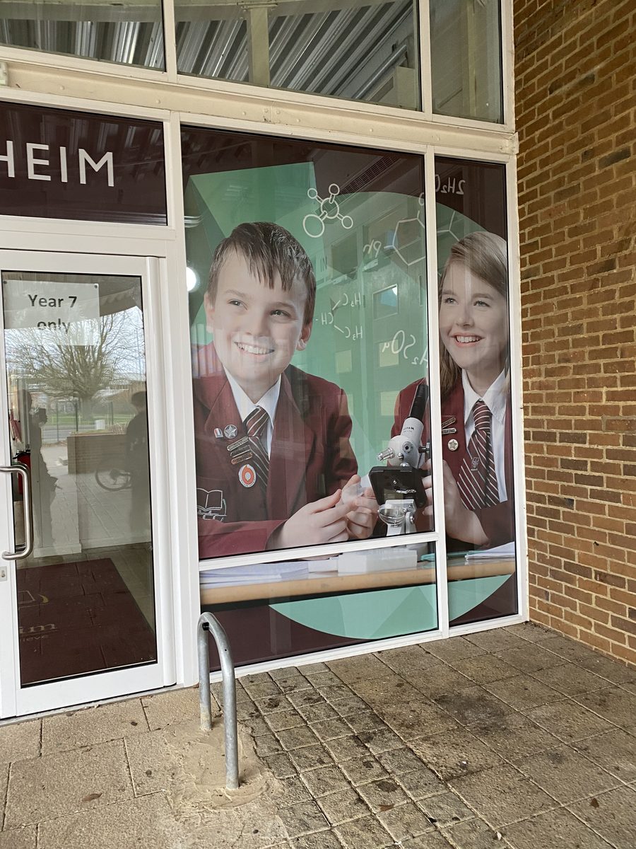 Blenheim school window with printed one-way vision graphic of two pupils using a microscope