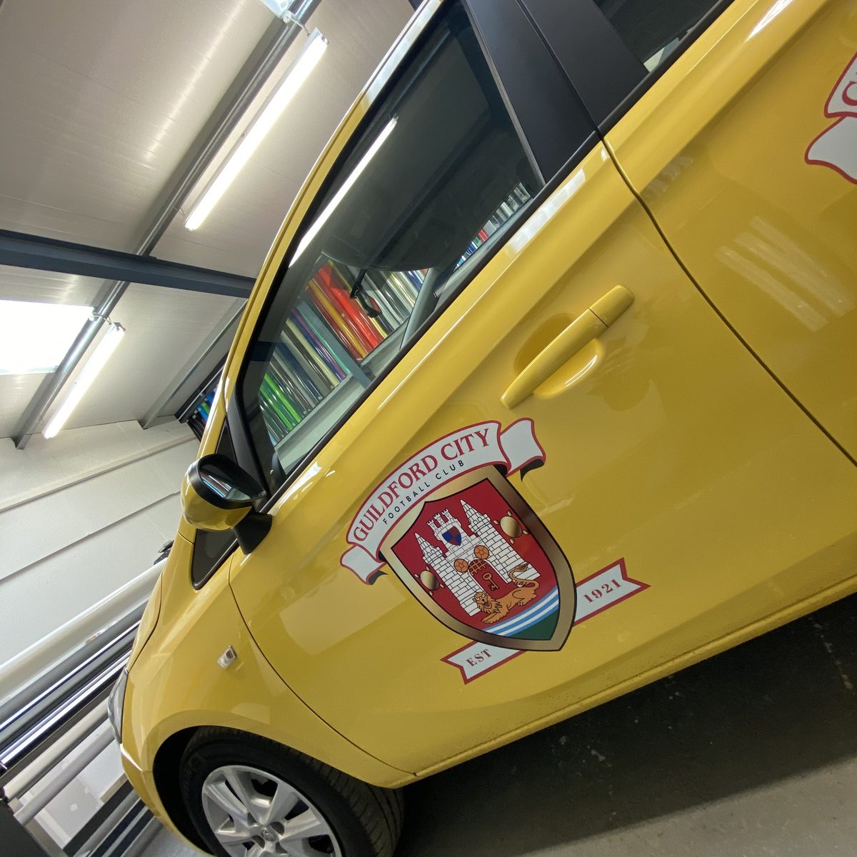 Yellow car door with a full-colour Guildford City Football Club crest and 'Est 1921' scroll
