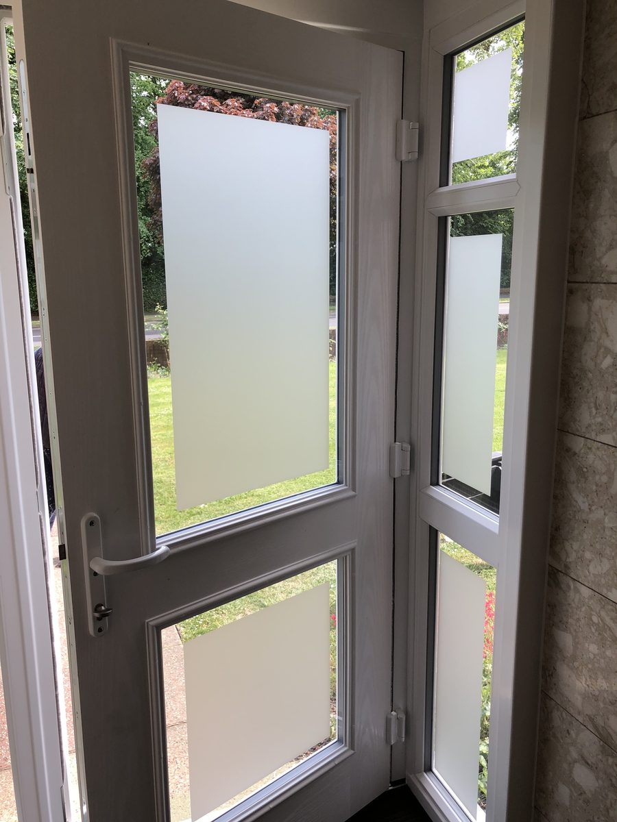 White uPVC door and side panel with frosted privacy film on the glazed panels